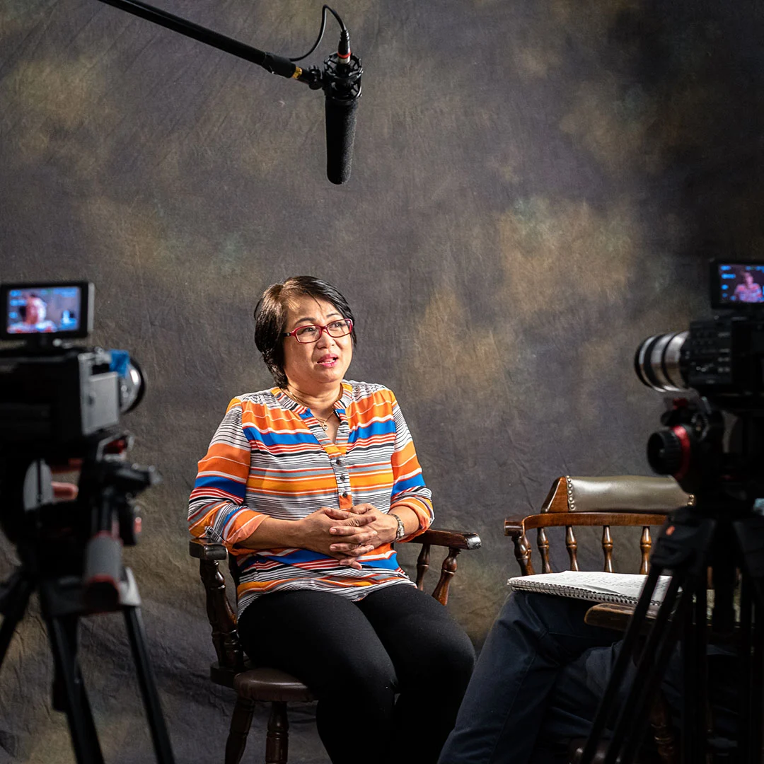 Een vrouw vertelt haar verhaal tijdens een interview in een opnamestudio.