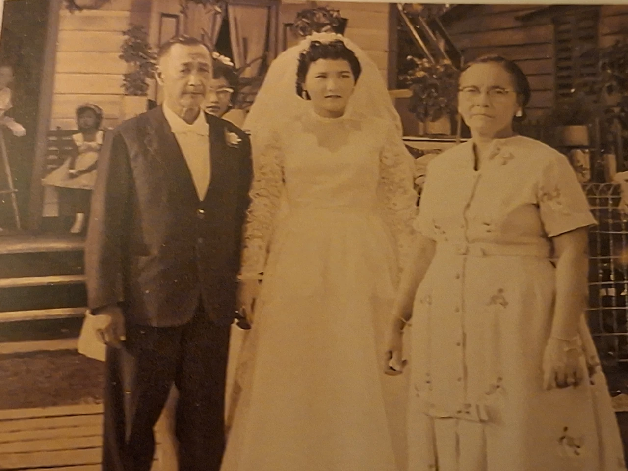 Historische sepiafoto van een bruid tussen een man en een vrouw.