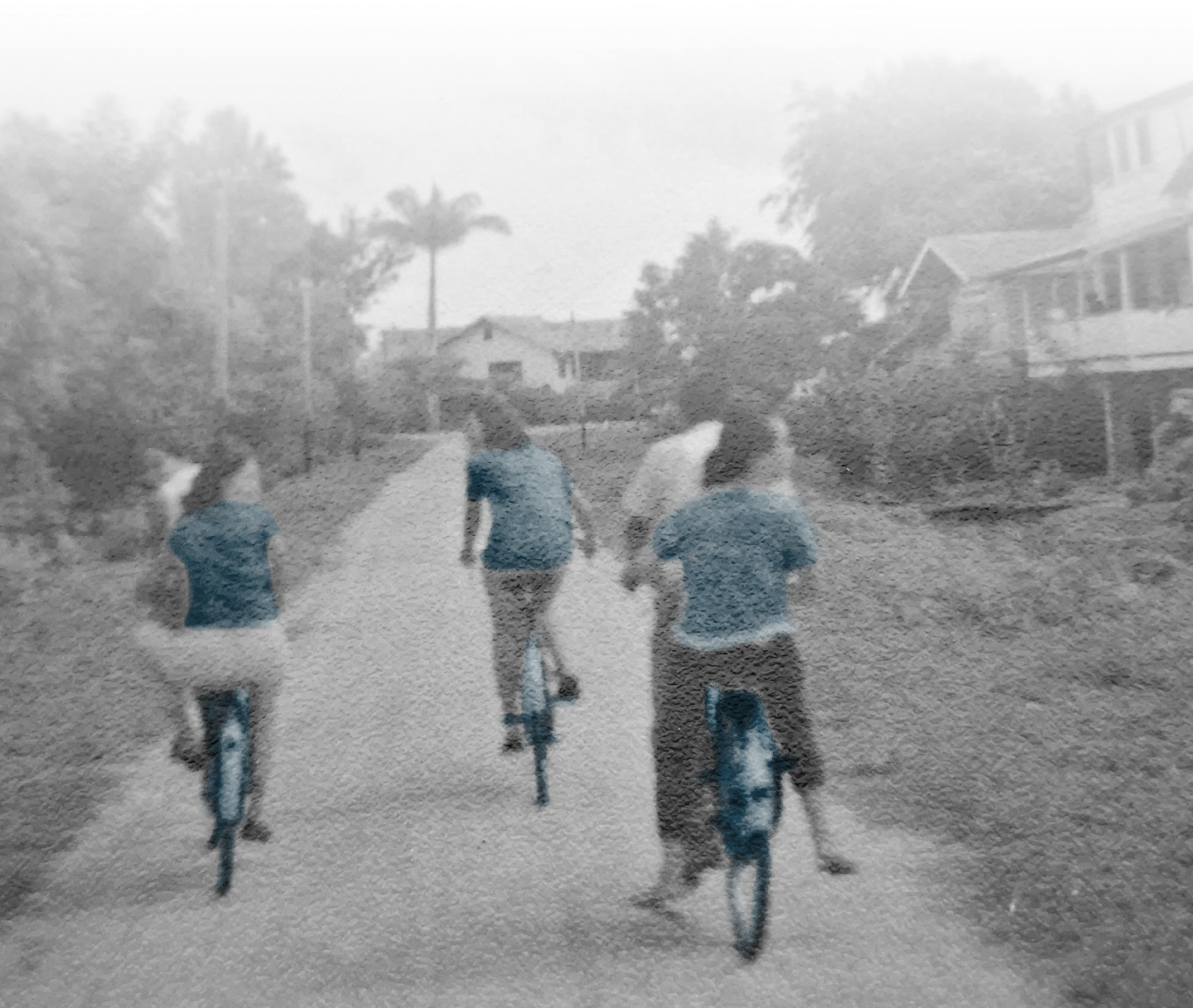 Historische archieffoto van vier mensen op fietsen op een onverharde weg