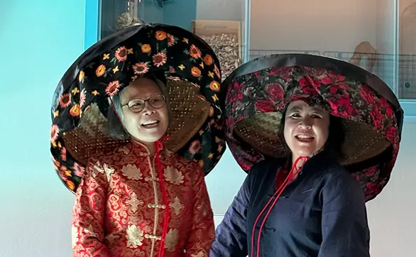 Twee mensen dragen rijk versierde traditionele hoofddeksels.
